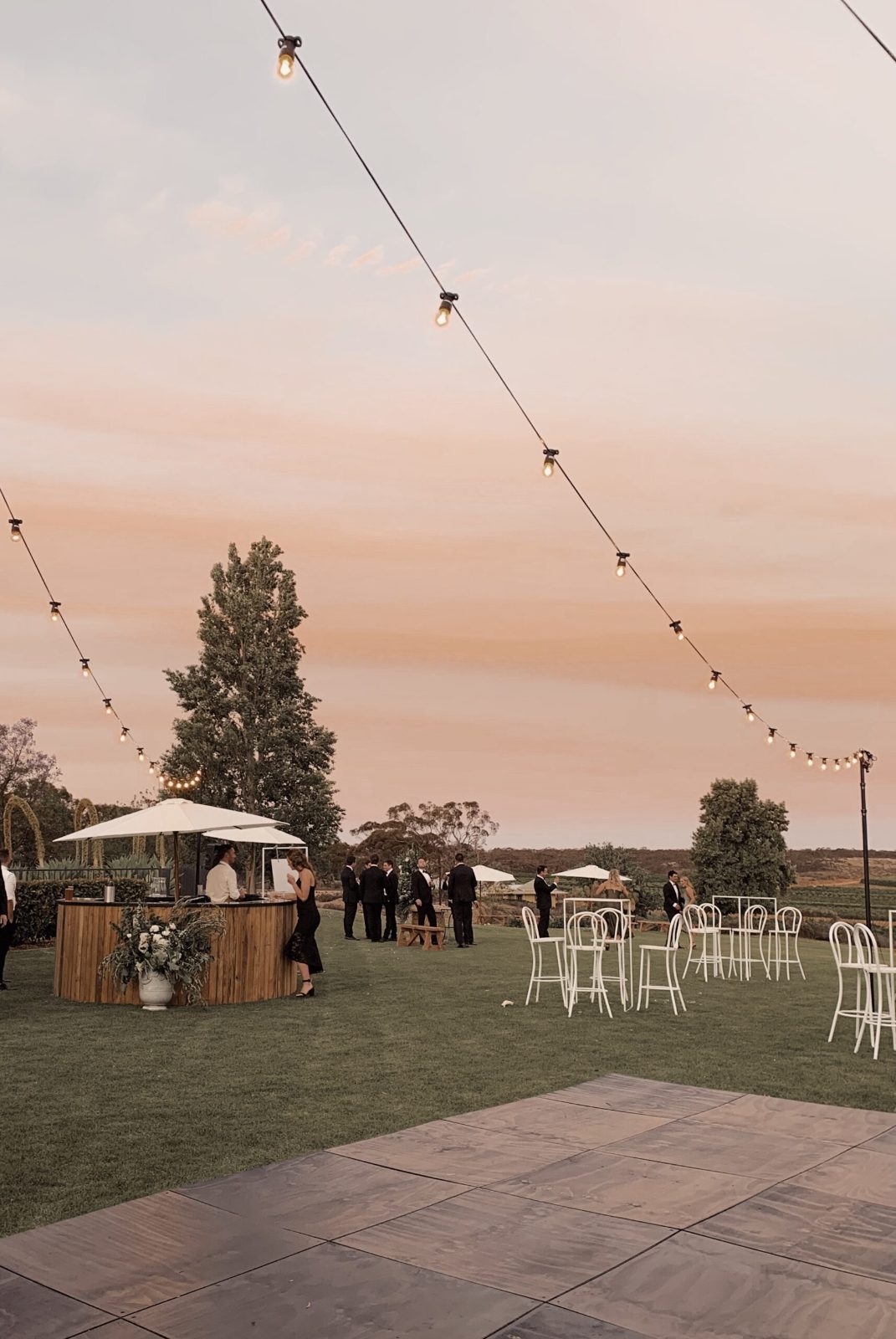 Outdoor reception space with string lights at dusk